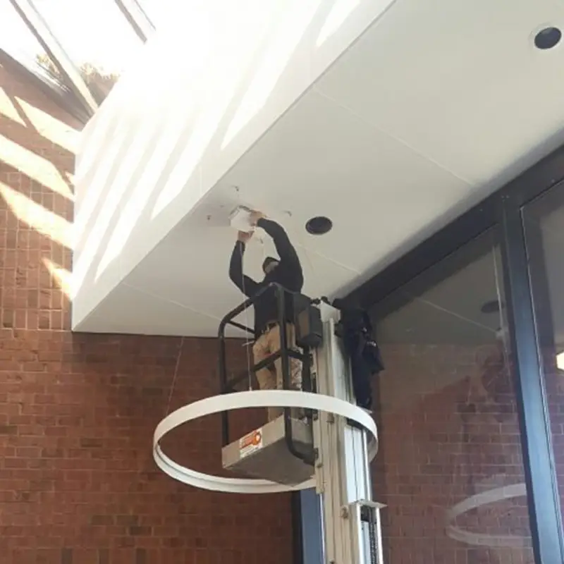 Electrician installing light fixtures.